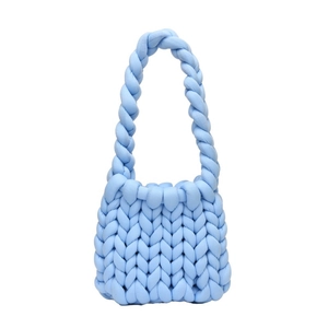 Handmade chunky knit shoulder bag in light blue polyester tube yarn on white background