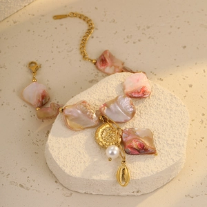 Golden stainless steel seashell bracelet with pink stones and pearls on white stones