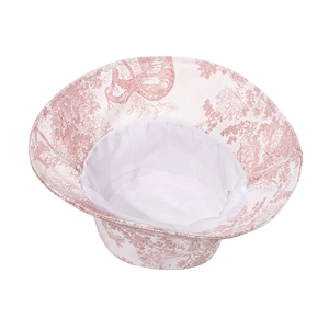 Detail of red toile de jouy print on white cotton sun hat with wide brim design
