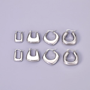 Flat lay of hollow crescent hoop earrings in silver stainless steel, variety set