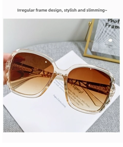 Detailed macro of oversized irregular tea gradient sunglasses with geometric hollow temples