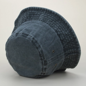 Détail d'un chapeau bob en denim délavé avec œillets métalliques et coutures renforcées