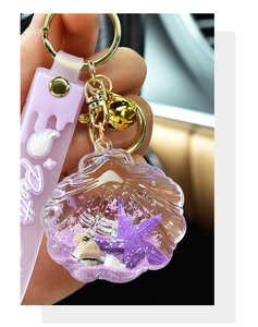 Detail of purple shell liquid keychain with floating starfish and Pretty silicone strap