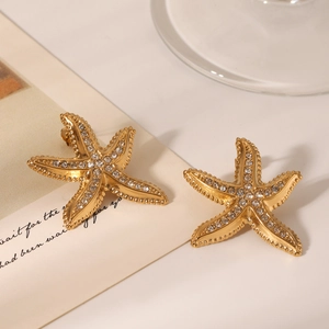 Detailed view of 18K gold starfish stud earrings with sparkling white crystals