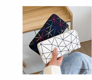 Close-up of geometric pattern laser wallets with zip closure and minimalist handle detail