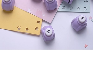Macro detail of purple mini DIY paper punches showing star and number patterns
