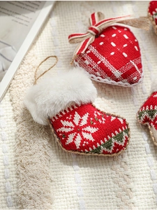 Detailed view of red knitted Christmas boot and heart ornaments with snowflake patterns