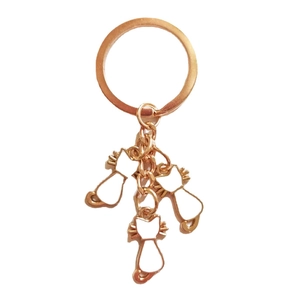 Golden metal keychain with three white enamel cat charms in various poses for cat lovers