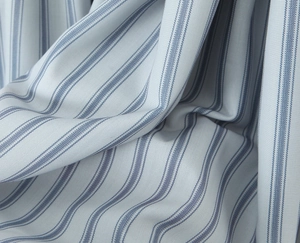 Close-up of light blue fabric with dark blue stripes showing the premium linen texture
