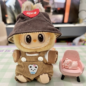 Detail of Labubu plush doll wearing brown corduroy overalls and a heart Love hat