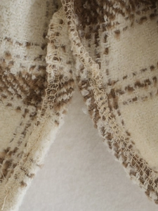 Vue macro détaillée d'un tissu écossais brossé avec des coutures surjetées de qualité