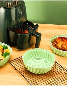 Teglia in silicone per friggitrice ad aria con pollo arrosto e verdure su un tavolo