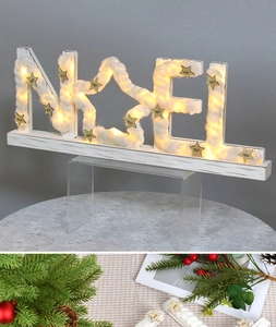 Close-up of wooden NOEL LED light with star details and warm Christmas ambiance