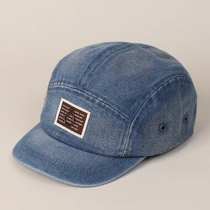 Detail van vintage blauwe denim baseballpet met bruine patch en metalen oogjes