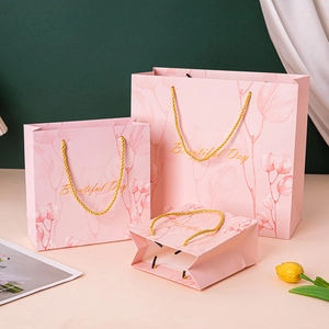 Pink gift bag with gold handles and leaf patterns for premium gift packaging