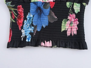 Close-up of floral print fabric with smocked elastic texture and ruffle hem detail