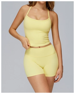 Detail of light yellow brushed yoga vest with halter straps and matching athletic shorts