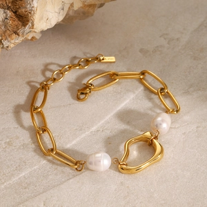 Detail of 18k gold chain bracelet with baroque pearls and irregular hollow charm pendant