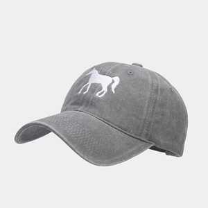 Close-up of refined horse embroidery and washed cotton fabric on dark grey baseball cap