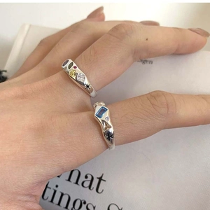Close-up of silver irregular molten rings with colorful zircon stones and star engravings