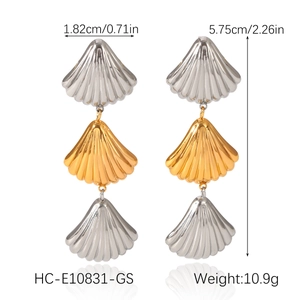 Detailed view of layered shell earrings in two-tone 18k gold and silver stainless steel