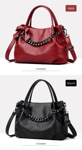 Close-up of red and black pebbled faux leather handbags with chunky metal chain and bows
