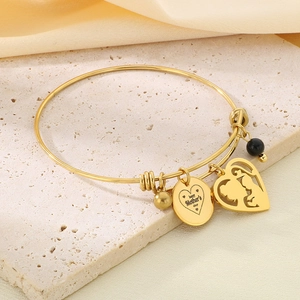 Detailed view of golden heart charms and Mother's Day engraving on adjustable bangle