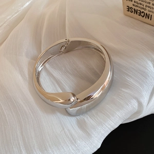 Detail of silver water drop hinge bracelet showing polished mirror finish and spring closure