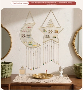 Detail of star and moon gold metal mesh wall jewelry organizer with hooks for earrings
