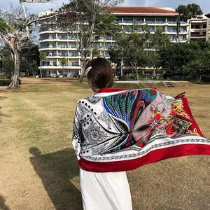 Close-up of lightweight red ethnic floral shawl blowing in the wind at a sunny resort