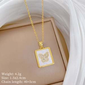 Close-up of titanium gold necklace with square shell pendant and butterfly crystal detail