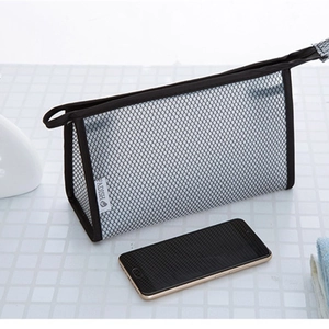 Gray mesh travel toiletry bag with black trim next to a smartphone for size reference