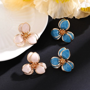 Makroaufnahme von mehrlagigen Emaille-Blumenohrringen in Rosa und Blau mit Golddetails