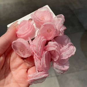 Detail of pink tulle flower earrings with 3D petals and delicate center pearl beads