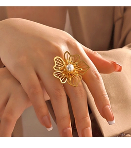 Detail of oversized gold floral statement ring with hollow petals and white pearl accent