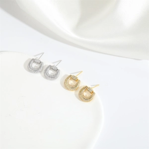 Macro shot of U-shaped earrings with micro-pave crystals in gold and silver finishes