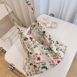 Detail shot of vintage red rose floral cotton tote bag on a white folding chair