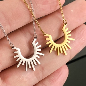 Détail de colliers soleil dorés et argentés avec des pendentifs en demi-cercle