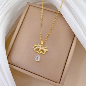 Macro shot of sparkling bow pendant with water drop zircon in a premium jewelry box