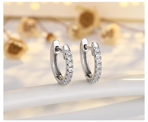 Macro shot of S925 sterling silver huggie earrings with sparkling cubic zirconia studs