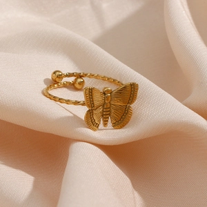 Detail of 18K gold butterfly open ring with twisted rope band on pink silk