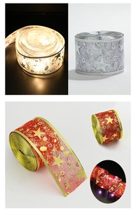 Detail of silver and red Christmas ribbon lights with LED stars and music note prints