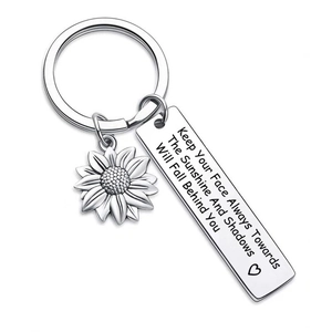 Detail of sunflower pendant and engraved inspirational quote on stainless steel keychain