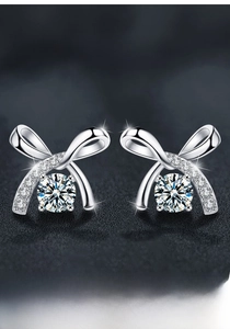 Dettaglio di orecchini a fiocco in argento S925 con pietre di moissanite rotonde