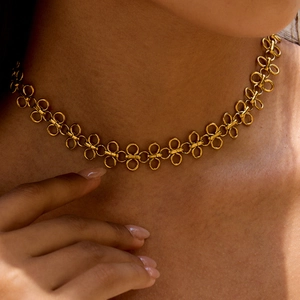 Minimalist gold titanium steel four-leaf clover necklace worn by a fashion model