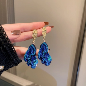 Macro shot of blue textured irregular heart drop earrings with gold metallic detail