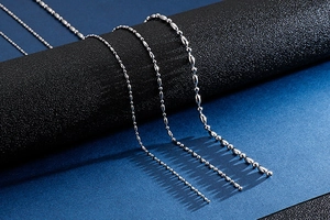 Detailed view of four silver stainless steel ball chains in various sizes and textures