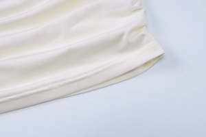 Dettaglio macro dell'abito bianco con spalle scoperte con cuciture e trama del tessuto