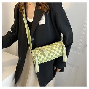 Detail of light green checkered barrel crossbody bag with wide adjustable shoulder strap