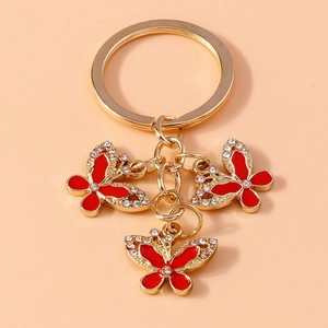 Detail of gold keychain with three sparkling red rhinestone butterfly pendants